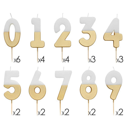Ten white and gold dipped number candles from 0 to 9 laid out in two rows