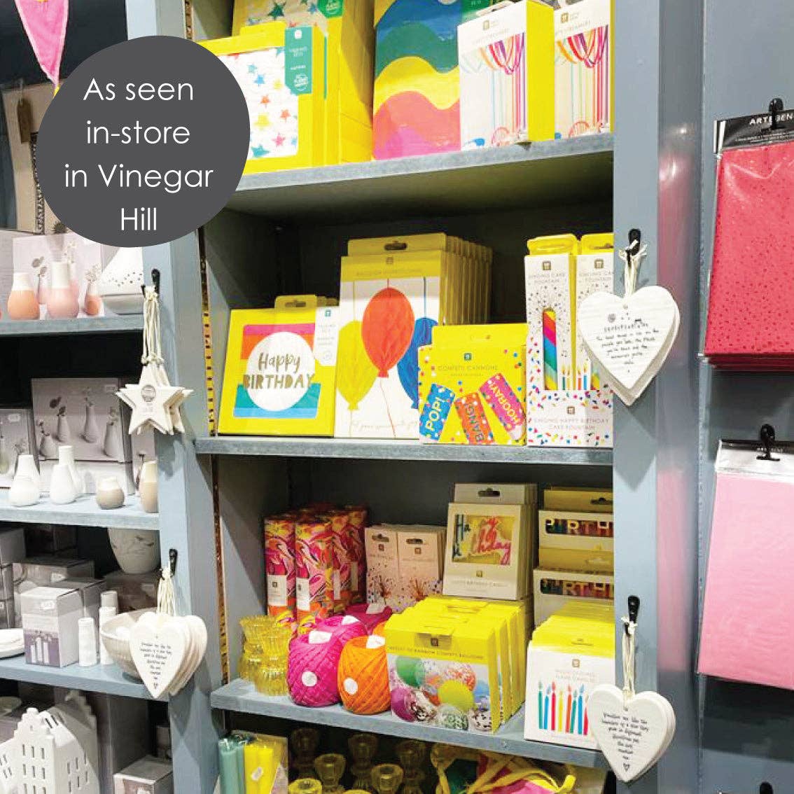 Shelves of colorful birthday party supplies in a gift shop
